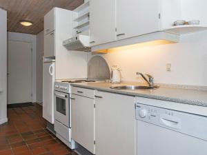 a kitchen with white cabinets and a sink at 6 person holiday home in Fan in Fanø