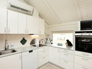 una cocina blanca con armarios blancos y fregadero en 6 person holiday home in Vejers Strand, en Vejers Strand