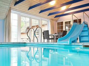 a indoor swimming pool with a slide and a slide slide at 14 person holiday home in Ulfborg in Husby