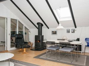イェアティングにある4 person holiday home in Esbjerg Vのリビングルーム(暖炉、テーブル、椅子付)