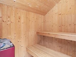 una sauna de madera con estanterías de madera y un cubo de basura rosa en 6 person holiday home in Ringk bing en Søndervig