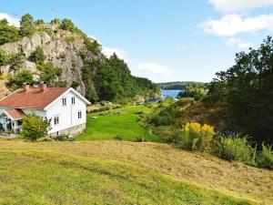 a house on a hill next to a body of water at Holiday Home Kystveien in Tvedestrand