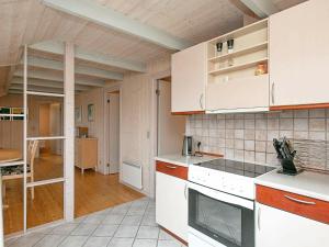 uma cozinha com armários brancos e uma escada em 6 person holiday home in Ringk bing em Søndervig