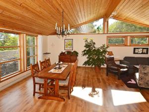 een woonkamer met een houten tafel en stoelen bij Holiday Home Kystveien in Tvedestrand