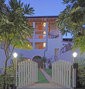 un bâtiment blanc avec une clôture devant dans l'établissement Apartments Villa Bougainville, à San Felice del Benaco