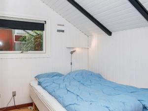 イェアティングにある4 person holiday home in Esbjerg Vの窓付きの白い部屋のベッド1台