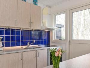 Hasleにある6 person holiday home in Hasleの青いタイル張りの壁、シンク付きのキッチンが備わります。