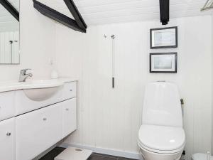 イェアティングにある4 person holiday home in Esbjerg Vの白いバスルーム(トイレ、シンク付)