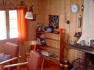 a living room with a fireplace and a clock on the wall at Three-Bedroom Holiday home in Nesbyen in Nesbyen