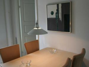 a dining room table with chairs and a light fixture at 4 person holiday home in Aakirkeby in Åkirkeby