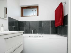 6 person holiday home in Bogense في بوجنسي: حمام أبيض مع حوض ومرآة