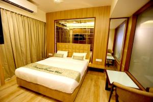 een slaapkamer met een bed, een tafel en een spiegel bij Silverador Boutique Hotel in Thane