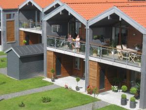 dos personas de pie en un balcón de una casa en 6 person holiday home in Bogense, en Bogense