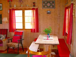 uma sala de jantar com uma mesa de madeira e cortinas vermelhas em Three-Bedroom Holiday home in Nesbyen em Nesbyen