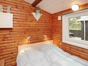 ホにあるThree-Bedroom Holiday home in Blåvand 77の木製の壁のベッドルーム(ベッド付)