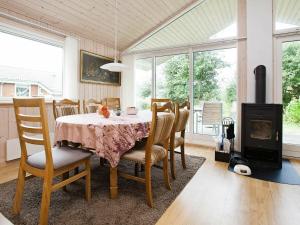a dining room with a table and chairs and a fireplace at Holiday Home Diget in Dannemare