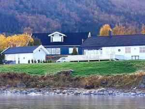 a large white house next to a river at 6 person holiday home in tomrefjord in Fiksdal