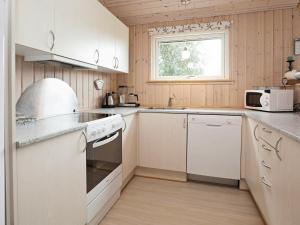 een keuken met witte apparatuur en een raam bij Holiday Home Diget in Dannemare