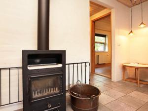 a wood stove in a room with a bucket at 12 person holiday home in H jslev in Bøstrup