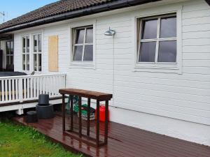 drewniany stół siedzący na ganku domu w obiekcie 6 person holiday home in tomrefjord w mieście Fiksdal