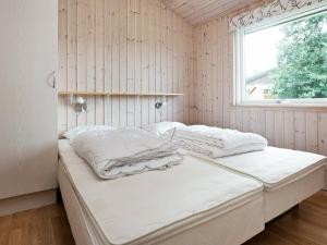 een wit bed in een kamer met een raam bij Holiday Home Diget in Dannemare