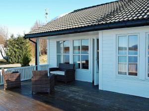 a porch with wicker chairs on a wooden deck at 6 person holiday home in tomrefjord in Fiksdal