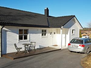 a white house with a table and chairs and a car at 6 person holiday home in tomrefjord in Fiksdal