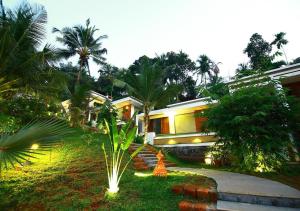 ein Haus mit Lichtern vor einem Hof in der Unterkunft Le Candles Resort in Kozhikode