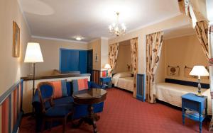 a hotel room with two beds and a table and chairs at Hotel König von Ungarn in Vienna