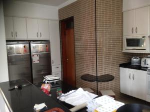 a kitchen with stainless steel appliances and a counter top at Hangaroa in Bertioga