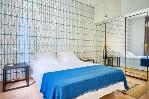 a bedroom with a large bed with a blue blanket at Apartamento en centro ciudad con vistas al mar in Málaga