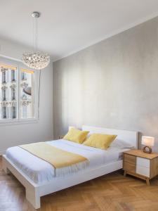 ein Schlafzimmer mit einem großen weißen Bett mit gelben Kissen in der Unterkunft Beautiful apartment in the heart of Nice in Nizza