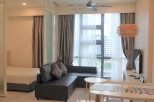 a living room with a black couch and a bed at The Robertson by KL MoonLight Suites Bukit Bintang in Kuala Lumpur