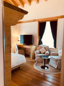 a living room with a couch and a tv at Hotel Alla Posta in Saint Vincent