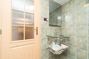łazienka z umywalką, lustrem i drzwiami w obiekcie Budyně Apartment w mieście Budyně nad Ohří +37 zdjęć