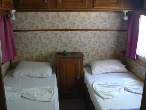 レティムノ・タウンにあるCamping Elizabethの紫色のカーテンが備わる小さな部屋のベッド2台
