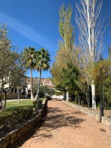 een loopbrug in een park met palmbomen en gebouwen bij Villa Remedios in Cuevas del Becerro