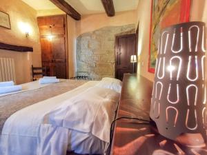 1 dormitorio con 1 cama grande y pared de piedra en Agriturismo Basaletto, en Asís