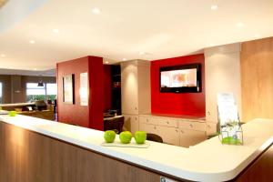 a lobby with a counter with green apples on it at Campanile Nîmes Centre Mas-Carbonnel in Nîmes