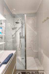 a shower with a glass door in a bathroom at Les Augustins in Amiens
