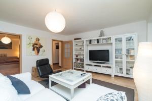 salon z białą kanapą i telewizorem w obiekcie Budyně Apartment w mieście Budyně nad Ohří