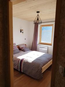 1 dormitorio con cama y ventana en Chez Papy - Grand Appart Entirely renovated Ventelon La Grave La Meije, en La Grave