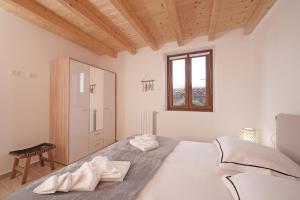 une chambre blanche avec un lit et une fenêtre dans l'établissement Apartments Villa Bougainville, à San Felice del Benaco