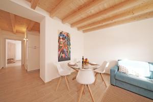 un salon avec un canapé bleu, une table et des chaises dans l'établissement Apartments Villa Bougainville, à San Felice del Benaco 51 autres photos