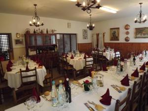 un comedor con mesas blancas y sillas con servilletas rojas en Albergo Ristorante Borghese, en Montereale Valcellina