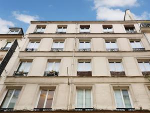 un grand bâtiment avec des fenêtres sur son côté dans l'établissement Rent a Room - Residence Caire, Montorgueil, à Paris