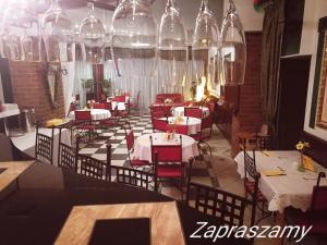 a dining room with tables and chairs and chandeliers at Rynkowy in Rybnik
