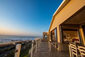 um edifício com uma varanda com vista para o oceano em Fairlight Beach House em Umdloti