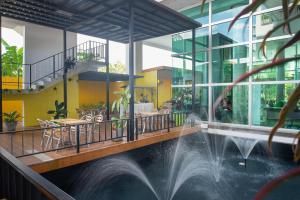 einen Pool in einem Gebäude mit einem Brunnen in der Unterkunft Eco Inn Prime Trang in Trang