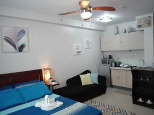 Mak'z Condo Place في ماكتان: غرفة معيشة مع سرير وأريكة